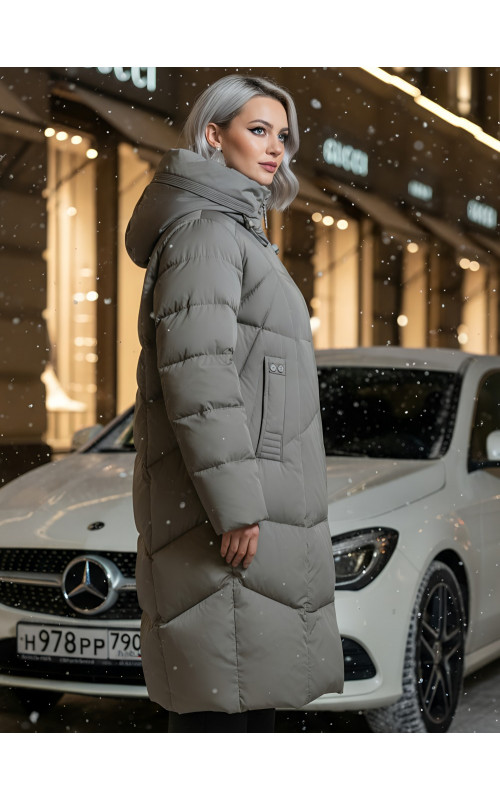 Длинный женский пуховик с капюшоном.