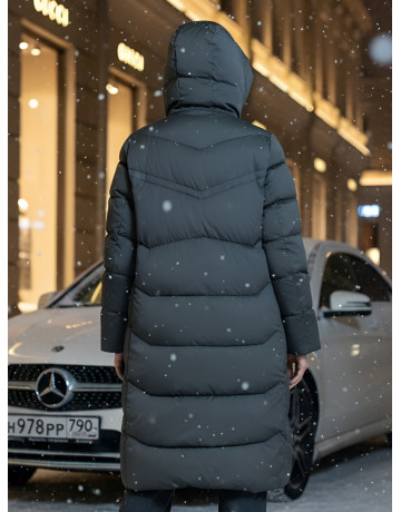 Длинный женский пуховик с капюшоном.